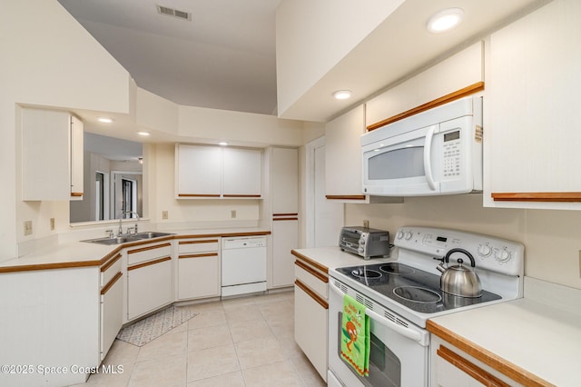 kitchen featuring a sink, visible vents, white appliances, and light countertops