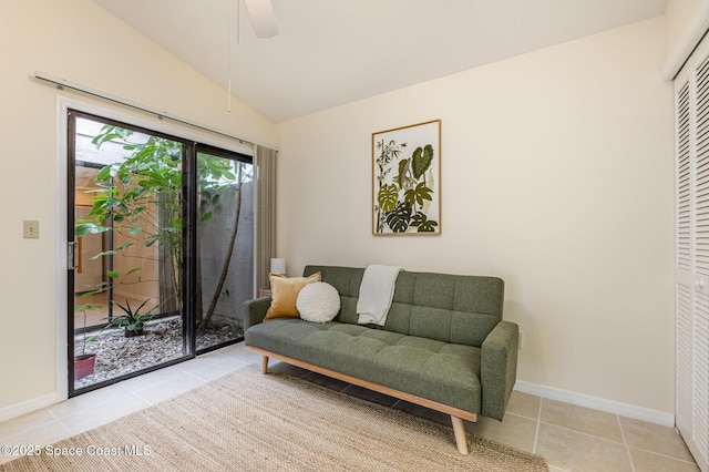 living area with tile patterned floors, a ceiling fan, baseboards, and vaulted ceiling