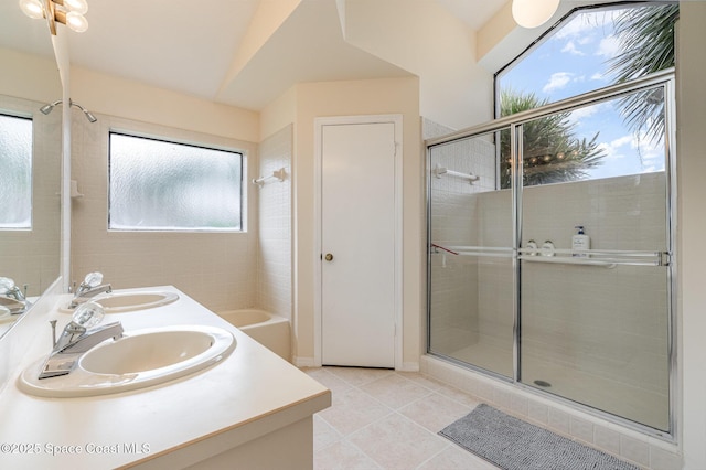 bathroom featuring tile patterned flooring, a shower stall, double vanity, and a sink