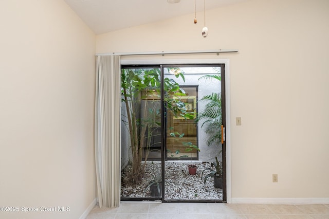 doorway featuring baseboards and vaulted ceiling