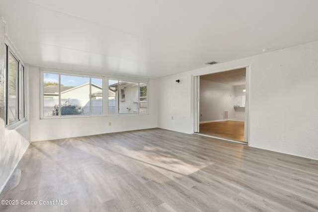 interior space with plenty of natural light, wood finished floors, and visible vents