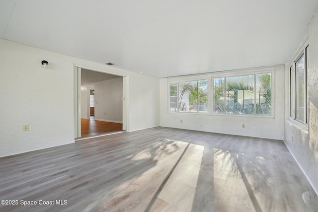 unfurnished room featuring wood finished floors and visible vents