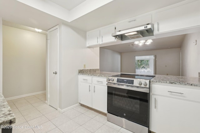 kitchen featuring under cabinet range hood, stainless steel electric stove, light tile patterned floors, and white cabinetry