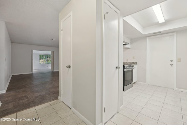 hallway featuring light tile patterned floors and baseboards