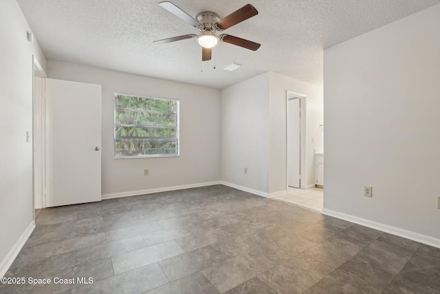 spare room featuring baseboards, a textured ceiling, and ceiling fan