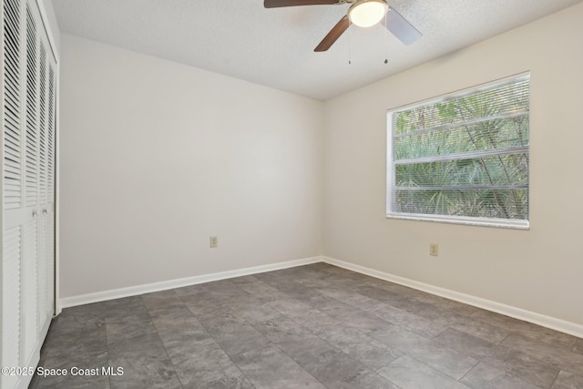 unfurnished bedroom with a closet, baseboards, a textured ceiling, and ceiling fan