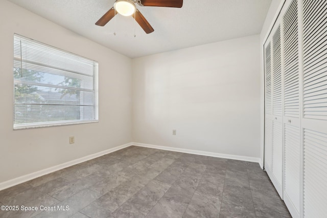 unfurnished bedroom featuring a closet, ceiling fan, and baseboards