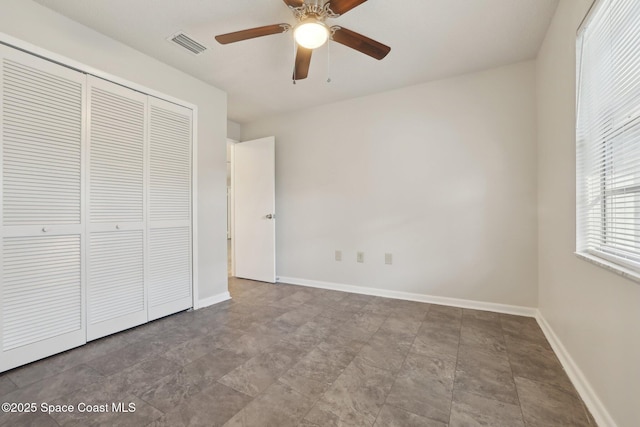 unfurnished bedroom featuring visible vents, baseboards, a closet, and ceiling fan