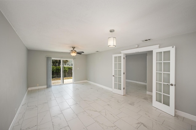 spare room featuring french doors, baseboards, marble finish floor, and visible vents