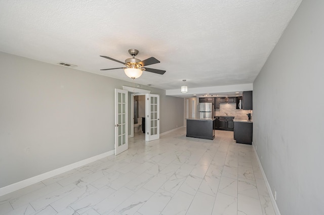 unfurnished living room featuring visible vents, marble finish floor, french doors, and baseboards