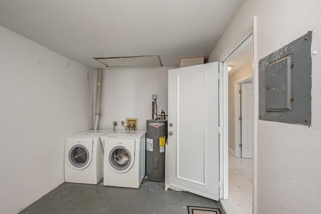 clothes washing area with electric panel, water heater, and washer and dryer