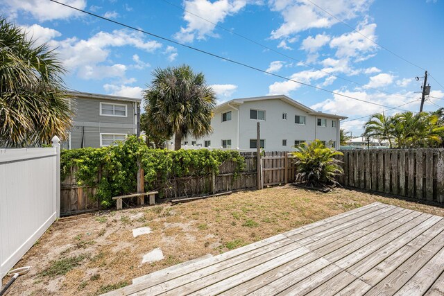 wooden deck with a fenced backyard