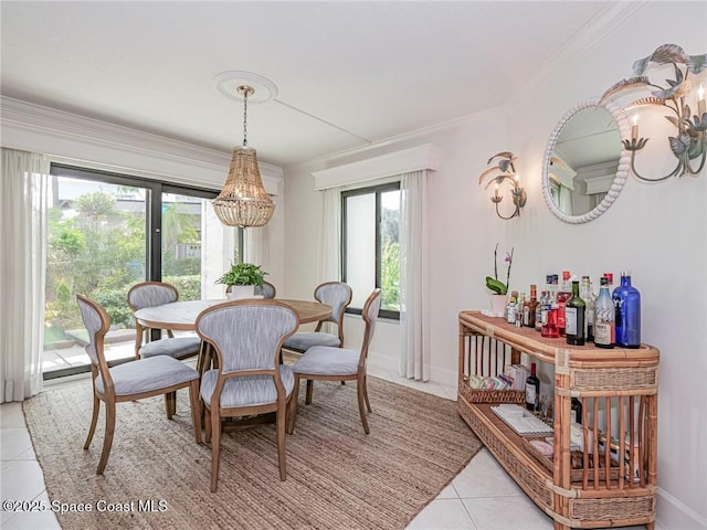 dining area featuring light tile patterned floors, baseboards, a healthy amount of sunlight, and ornamental molding