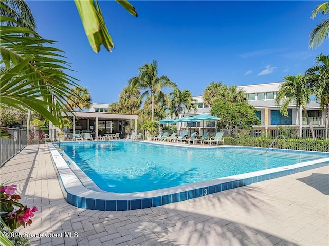 community pool featuring a patio area and fence