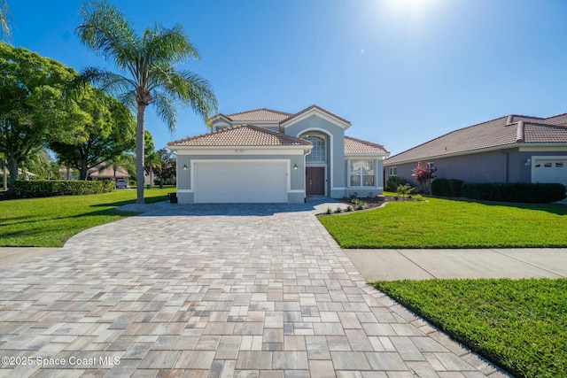 mediterranean / spanish-style house featuring a tile roof, a front lawn, decorative driveway, and a garage