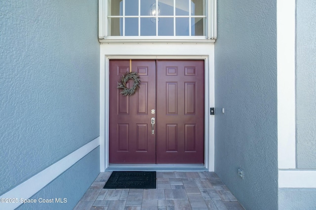 property entrance with stucco siding