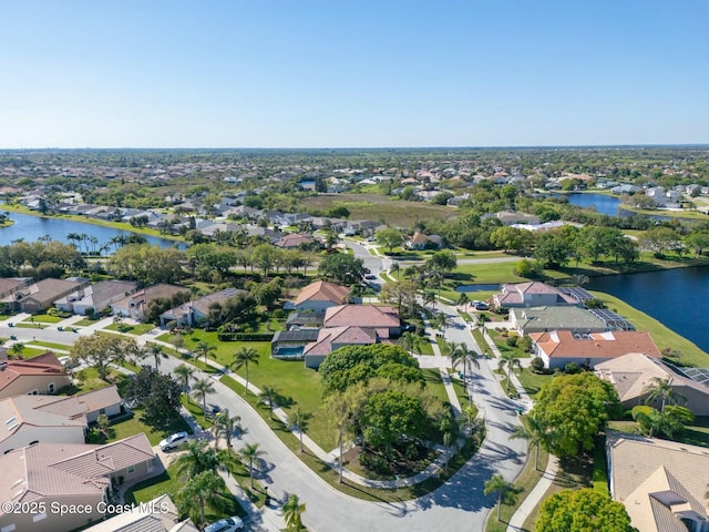 drone / aerial view featuring a residential view and a water view