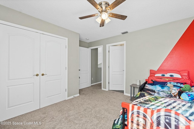 carpeted bedroom with a closet, visible vents, ceiling fan, and baseboards