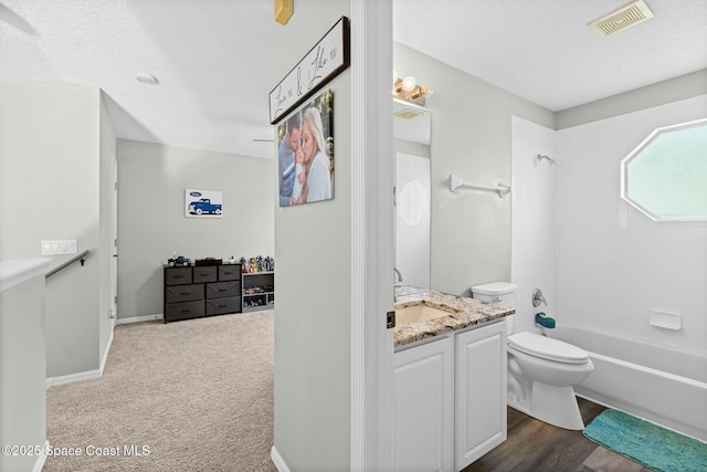 full bathroom featuring visible vents, toilet, a textured ceiling, washtub / shower combination, and vanity