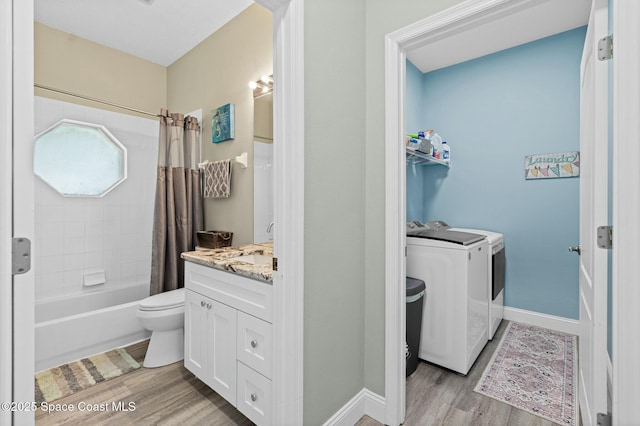 full bath with vanity, wood finished floors, baseboards, washing machine and clothes dryer, and toilet