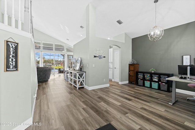 entryway featuring visible vents, arched walkways, high vaulted ceiling, and wood finished floors