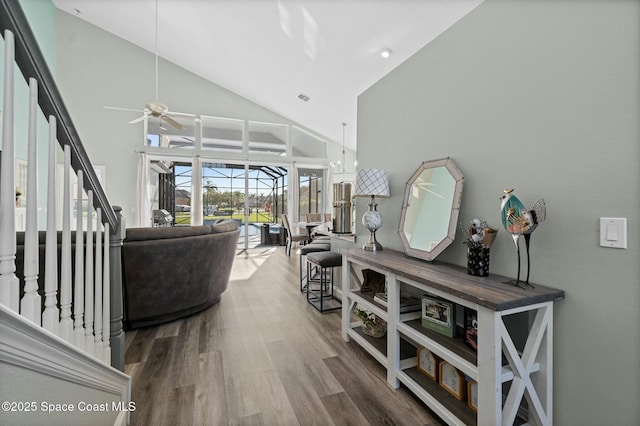 living room featuring ceiling fan, high vaulted ceiling, wood finished floors, and a sunroom