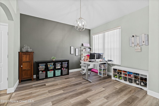 office area featuring arched walkways, a chandelier, baseboards, and wood finished floors