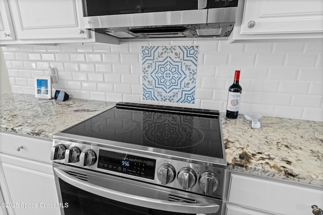 kitchen featuring decorative backsplash, white cabinets, and appliances with stainless steel finishes