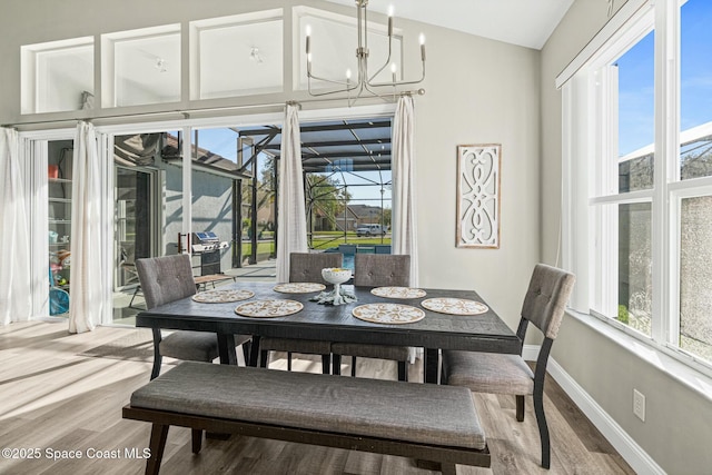 dining area with wood finished floors, baseboards, a wealth of natural light, and a chandelier