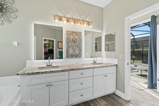 bathroom featuring double vanity, wood finished floors, and a sink