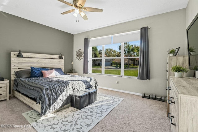 bedroom featuring light colored carpet, baseboards, and ceiling fan