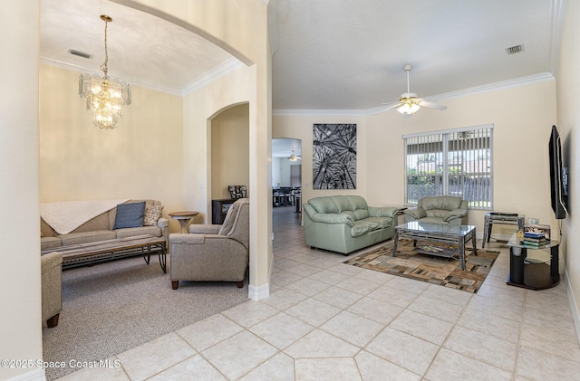 tiled living room with visible vents, arched walkways, crown molding, and ceiling fan with notable chandelier