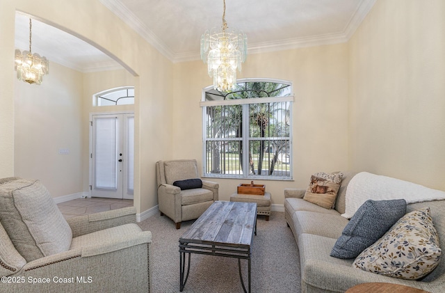 living area featuring an inviting chandelier, crown molding, arched walkways, and baseboards