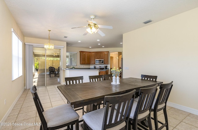 dining space featuring light tile patterned floors, visible vents, arched walkways, and baseboards