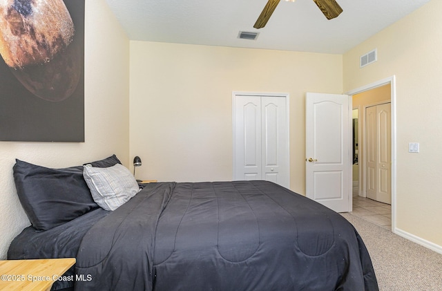 bedroom with a closet, visible vents, carpet flooring, and a ceiling fan