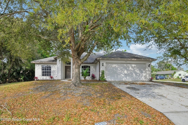 single story home with stucco siding, concrete driveway, and an attached garage