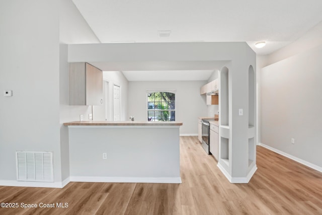 kitchen featuring light wood-type flooring, visible vents, baseboards, and stainless steel range with electric stovetop