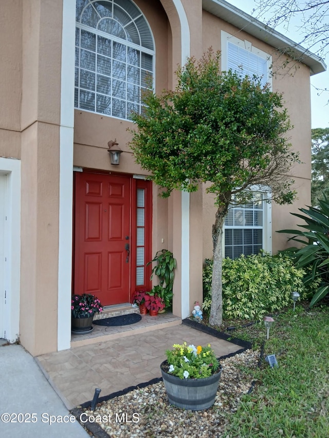 doorway to property featuring stucco siding