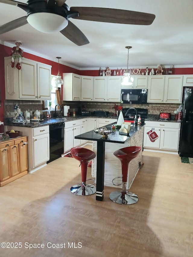 kitchen with pendant lighting, black appliances, a ceiling fan, dark countertops, and decorative backsplash