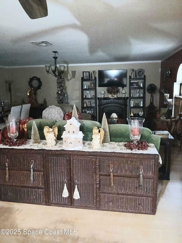 living area with visible vents, ornamental molding, and a fireplace