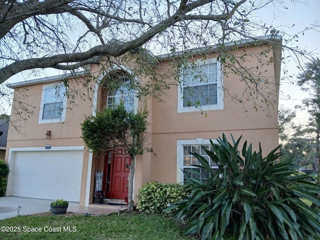 view of front of property with concrete driveway, a garage, and stucco siding