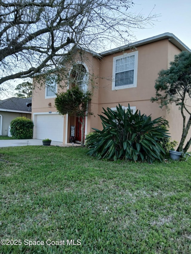 traditional-style home featuring stucco siding, driveway, an attached garage, and a front yard