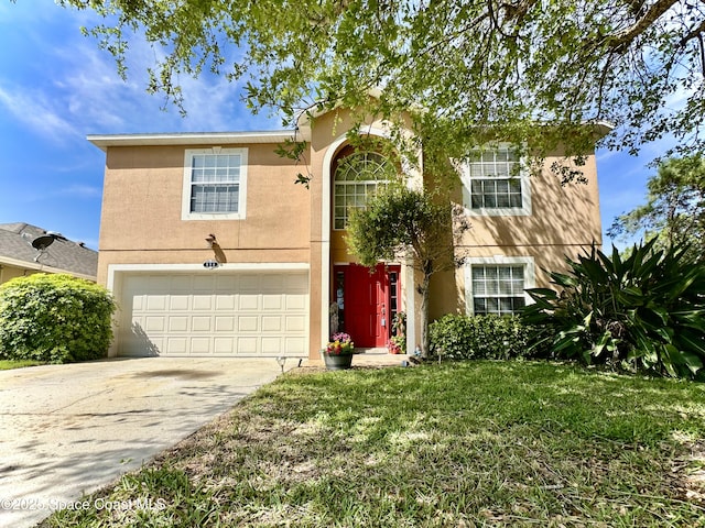 traditional home featuring a front lawn, an attached garage, driveway, and stucco siding