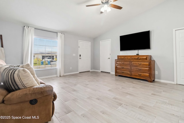 sitting room with light wood finished floors, ceiling fan, baseboards, and lofted ceiling