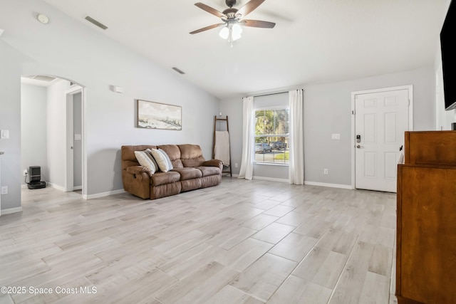 living area featuring light wood-type flooring, a ceiling fan, arched walkways, baseboards, and vaulted ceiling