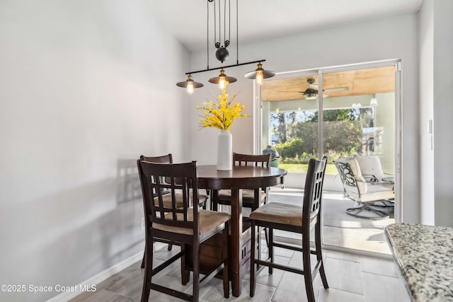 dining area featuring a ceiling fan and baseboards