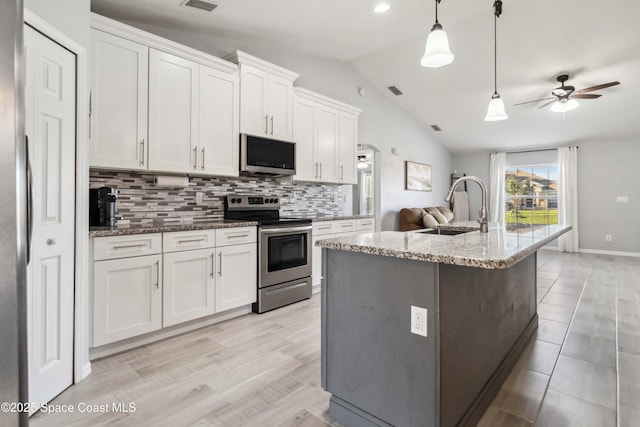 kitchen featuring a sink, vaulted ceiling, appliances with stainless steel finishes, white cabinetry, and backsplash