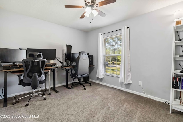 carpeted office space with baseboards and a ceiling fan