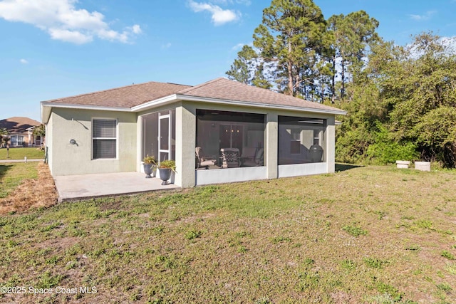 back of house with roof with shingles, a lawn, stucco siding, a sunroom, and a patio