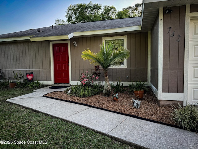 doorway to property with roof with shingles